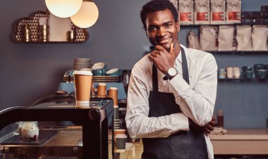 Başarılı Afro-Amerikan sahibi küçük işletme kamera coffee shop dururken gülümseyen portresi.