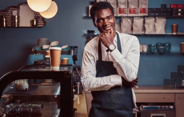Başarılı Afro-Amerikan sahibi küçük işletme kamera coffee shop dururken gülümseyen portresi.