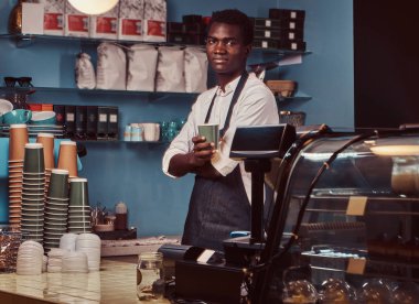 Yakışıklı bir Afrika barista trendy coffee shop kontuarında portresi.