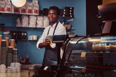 Yakışıklı bir Afrika barista trendy coffee shop kontuarında portresi.