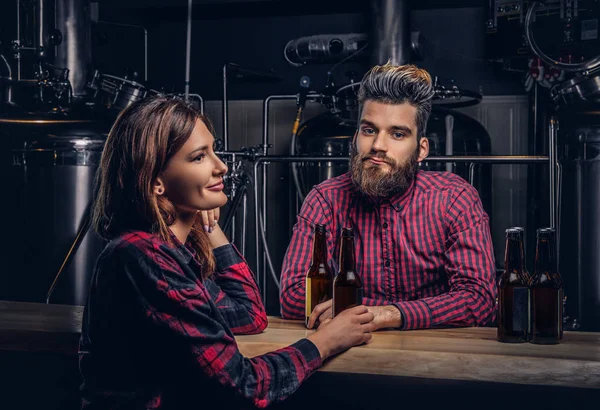 Bebaarde man en zijn vriendin genieten van ambachtelijke bier tijdens het daten in indie brouwerij. — Stockfoto