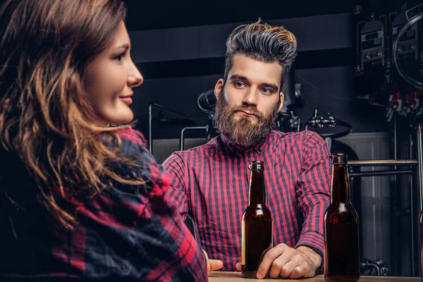 Bebaarde man en zijn vriendin genieten van ambachtelijke bier tijdens het daten in indie brouwerij. — Stockfoto