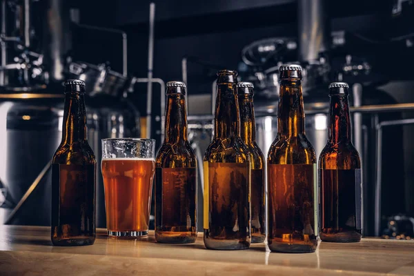 Flaskor och glas hantverk öl på trä bar counter på indie bryggeriet. — Stockfoto