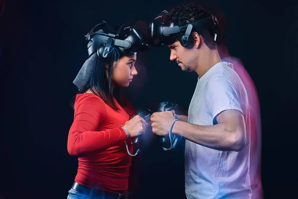 Un par de jugadores profesionales con auriculares VR participan en la batalla del juego. Foto con efecto de luz . — Foto de Stock