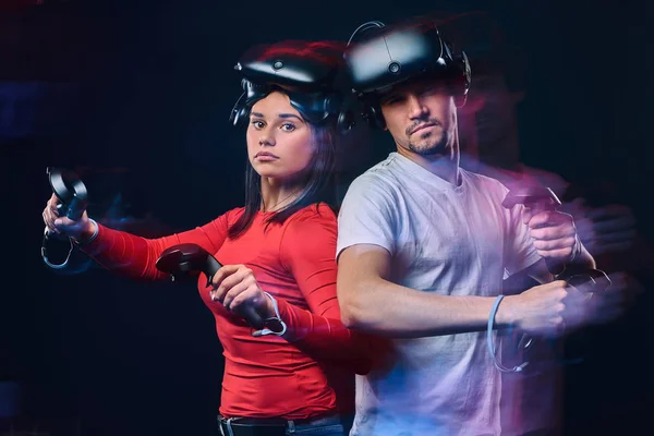 Portret van een jonge Kaukasische paar poseren met Vr headsets en controllers. — Stockfoto