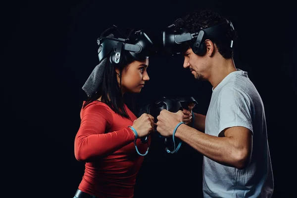 Inicio de la competencia y la confrontación. Pareja de jugadores profesionales con auriculares VR participan en la batalla del juego . — Foto de Stock