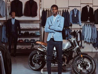 Afrikalı-Amerikalı genç adam şık giyinmiş retro poz motosiklet Erkek Giyim Mağazası, spor.