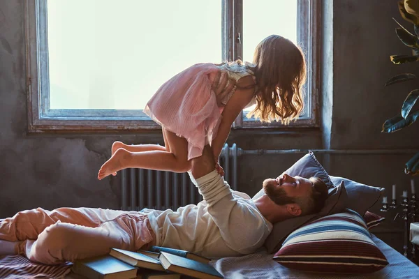Vater und Tochter im Bett. Vater spielt mit entzückender Tochter im Schlafzimmer. — Stockfoto