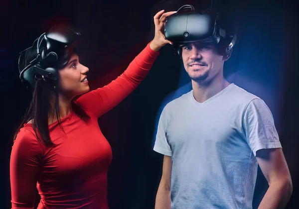 Vrolijke meisje past VR bril op haar vriendje. Paar gamers met Vr headsets. — Stockfoto