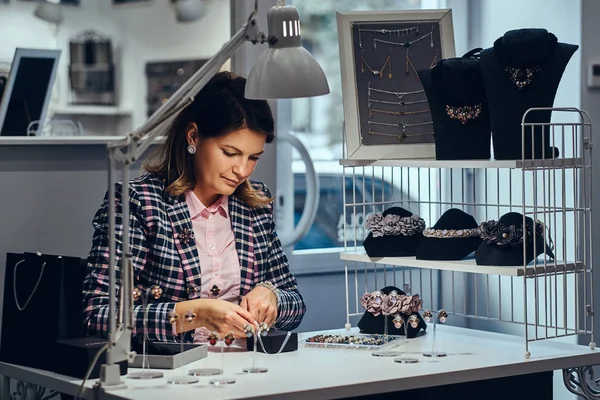 Mujer vendedor paquetes preciosos pendientes en una caja para su cliente en una joyería de lujo . — Foto de Stock