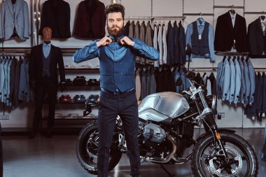 Şık adam giyinmiş şık papyon retro yakınındaki el ile poz giyim spor motosiklet Erkek Giyim Mağazası,.
