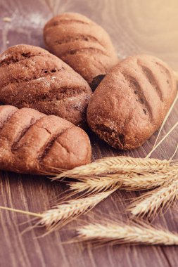 Lezzetli taze ekmek yapım ürünleri ve buğday ahşap arka plan üzerinde spikelets.