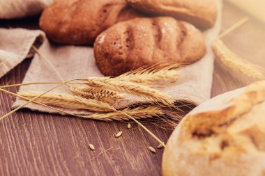 Lezzetli taze ekmek yapım ürünleri ve buğday ahşap arka plan üzerinde spikelets.