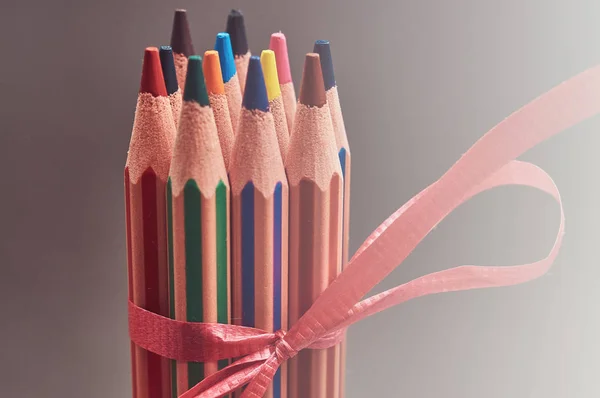 赤いギフト リボンで飾られた色とりどりの鉛筆のグループ. — ストック写真