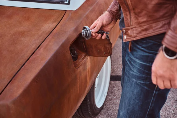Mužské ruky otevírá uzávěr plynu laděný retro auta k tankování. — Stock fotografie