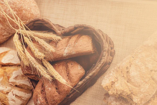 Freshly bakery products and spikelets on cloth at home. — Stock Photo, Image