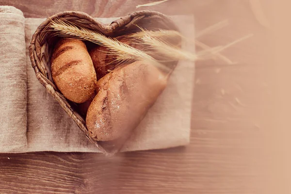 Hot freshly buns in a heart-shaped basket. — Stock Photo, Image