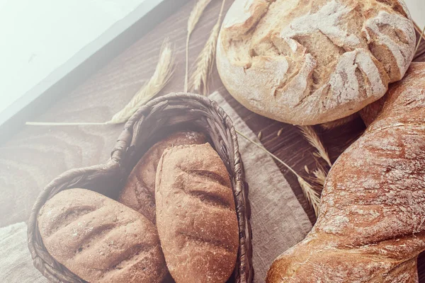 Heiße frische Brötchen in einem herzförmigen Korb. — Stockfoto