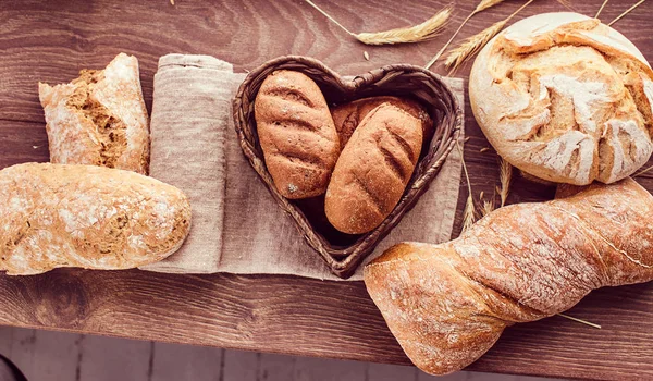 Hot freshly buns in a heart-shaped basket. — Stock Photo, Image