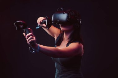 Güzel genç kadın sanal gerçeklik kulaklık ve video oyunları oynarken oyun çubukları.