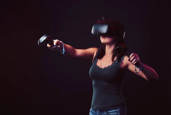 美丽的年轻妇女与虚拟现实耳机和操纵杆玩视频游戏. — 图库照片