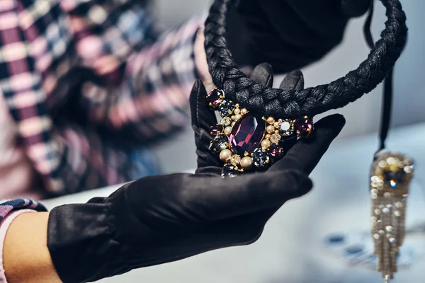 Foto de cerca de un joyero que presenta un costoso collar con piedras preciosas en una joyería . —  Fotos de Stock