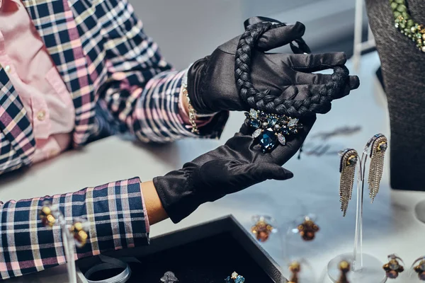 Pahalı bir kolye gemstones bir mücevher mağazası ile sunan bir takı işçinin yakın çekim fotoğraf. — Stok fotoğraf