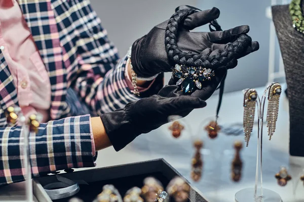 Foto de cerca de un joyero que presenta un costoso collar con piedras preciosas en una joyería . — Foto de Stock