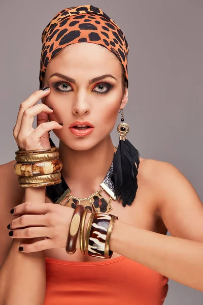 Belle femme caucasienne avec maquillage portant châle coloré sur la tête et les accessoires. Isolé sur fond gris . — Photo