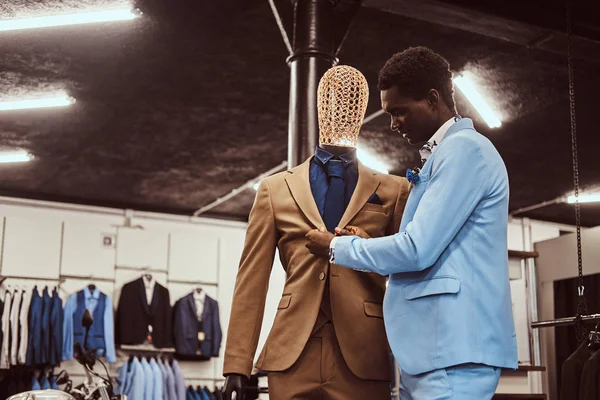 Elegant klädd afroamerikansk man som arbetar på klassiska herrkläder butik. — Stockfoto