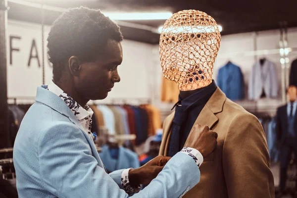 Elegant klädd afroamerikansk man som arbetar på klassiska herrkläder butik. — Stockfoto