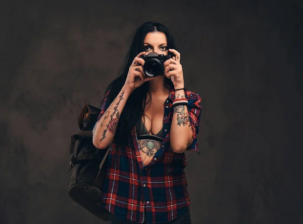 Förförisk tatuerade hipster flickan bär en röd uppknäppt rutig skjorta poserar en kamera. — Stockfoto