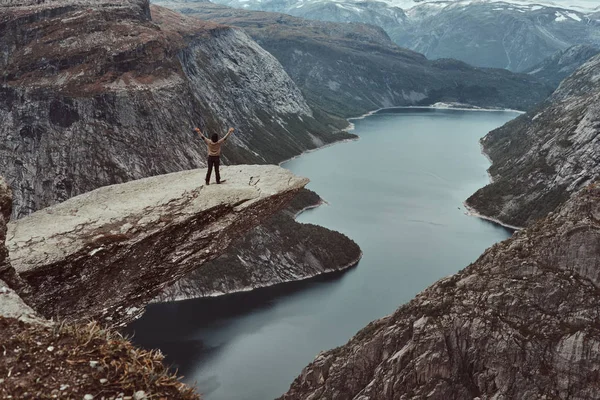 観光客女性が立っている、Trolltunga、ノルウェーのフィヨルドの美しい景色を楽しんでいます. — ストック写真