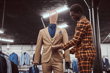 Klasik erkek giyim mağazasında çalışan trendy şık takım elbise, Afrikalı-Amerikalı adam giymiş.