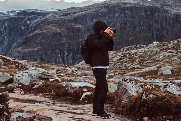 Fotógrafo de natureza turista com tiros de câmera enquanto está em pé na montanha . — Fotografia de Stock