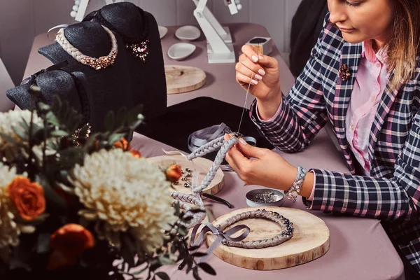 İğne ve iplik atölyesinde çalışan el yapımı kolye, zarif giyimli kadın yapar.