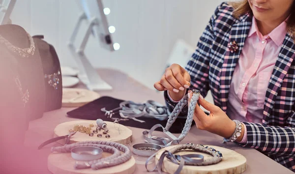 Elegant gekleed vrouw maakt handgemaakte kettingen in sieraden workshop. — Stockfoto