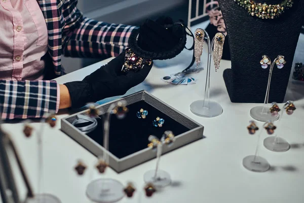 Foto de cerca de un joyero que presenta un costoso collar con piedras preciosas en una joyería . — Foto de Stock