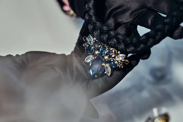 Close-up photo of a jewelry worker presenting a costly necklace with gemstones in a jewelry store. — Stock Photo, Image