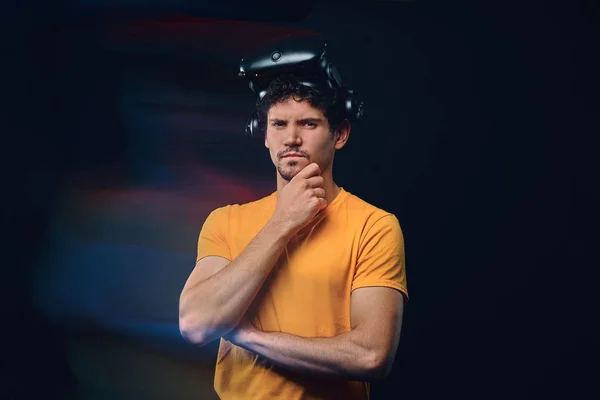Retrato de um homem pensativo com cerda em camisa amarela vestindo óculos de realidade virtual . — Fotografia de Stock