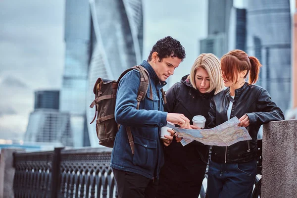 Groep toeristen zoeken op de kaart voor wolkenkrabbers — Stockfoto