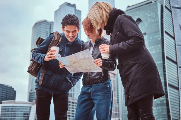 Groep toeristen zoeken op de kaart voor wolkenkrabbers — Stockfoto