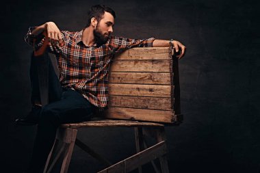 İşçisi, marangoz, karanlık bir arka plan üzerinde izole bir stüdyoda bir testere tutan el işleri ustası.