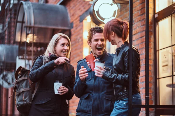 Трое друзей-студентов отдыхают за чашечкой кофе возле кафе. . — стоковое фото