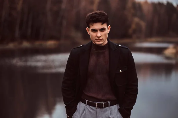 Un joven guapo y confiado en el bosque de otoño . — Foto de Stock