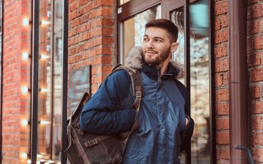 Yakışıklı bir genç adam dışında bir kafe yakın duran.