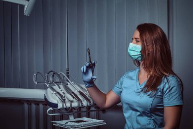 Dişçi ofisinde otururken kadın dişçi holding şırınga.