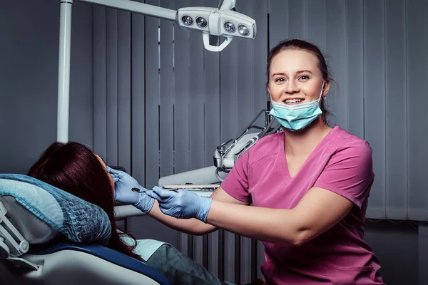 Una giovane donna che fa un esame mentre siede sulla sedia dei dentisti con la bocca aperta . — Foto Stock