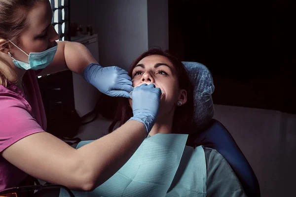 Młoda kobieta o badanie siedząc w fotelu Dentyści z otwarte usta. — Zdjęcie stockowe