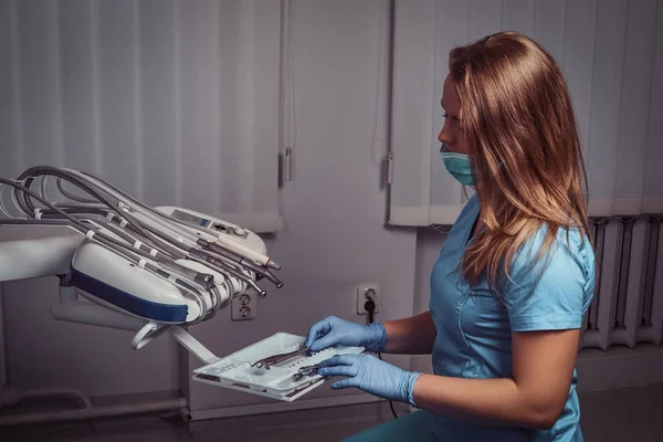 Dentista mulher sentada em uma cadeira em seu local de trabalho em uma clínica odontológica . — Fotografia de Stock